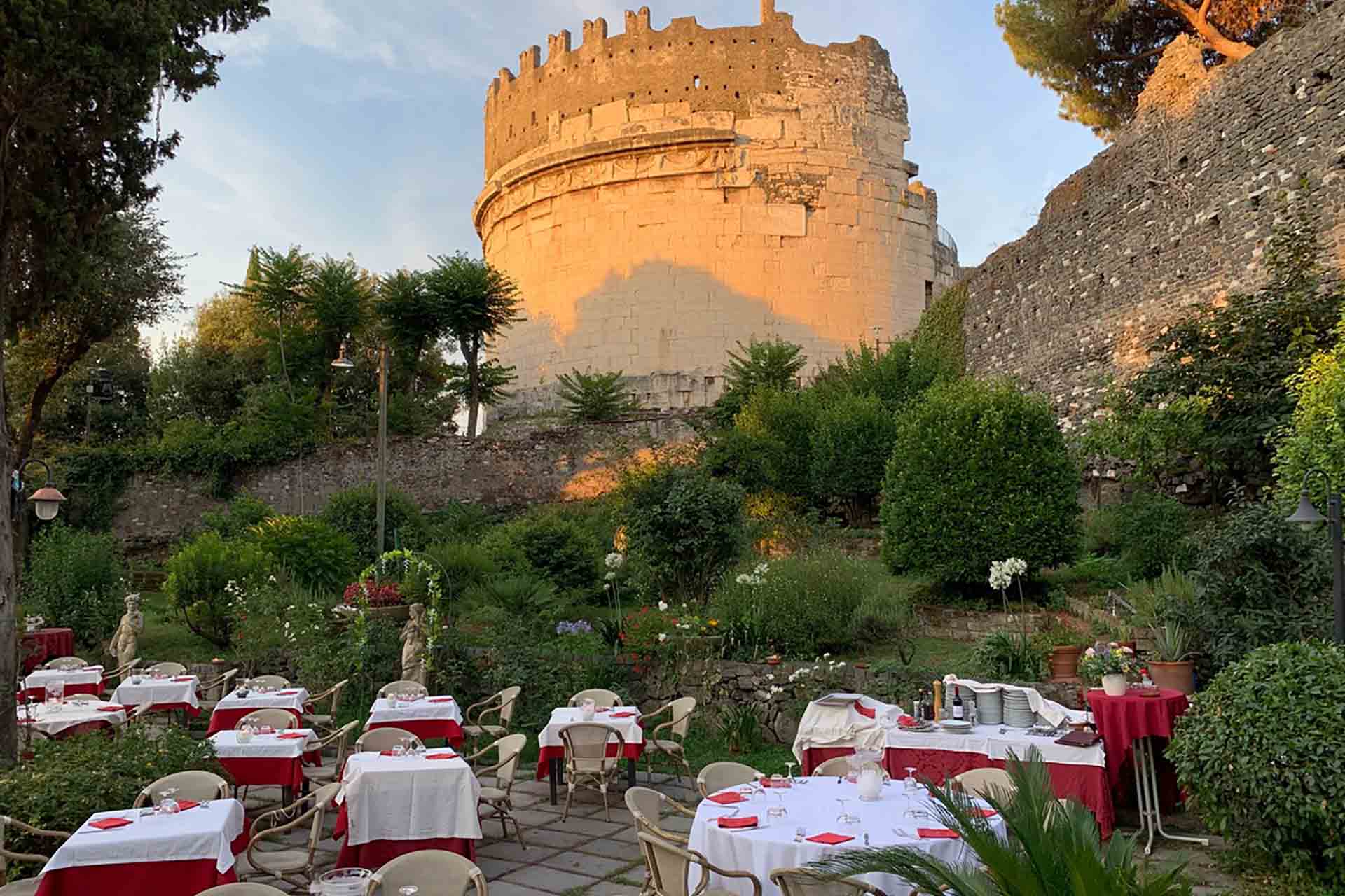 The garden of Hostaria Antica Roma at sunset, beneath an ancient Roman tomb on the Appian Way.